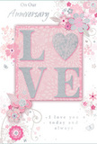 This anniversary card presents a quiet yet deeply romantic design, much like a refined bouquet chosen for a special dinner at home in Wapping. The main feature is the word LOVE, gently raised and softened with a dusting of pale glitter, with the letter O transformed into a shimmering silver heart that adds a focal shimmer. This heart, slightly textured, catches the light with a subtle sparkle, evoking the glint of a ring or the reflection of water along the Wapping shoreline. The surrounding palette is made up of soft pastel pinks, silvery greys, and hints of white, coming together like the petals of blush-toned roses nestled with silvery foliage. Around the central word, delicate flowers and curling vines spread across the card, rendered with a watercolour softness that suggests petals unfurling in slow motion. Their outlines are fine and fluid, with blush and mauve blooms that call to mind romantic, springlike arrangements often delivered to homes near Wapping High Street or close to St Katharine Docks. Tiny details-petals, whimsical swirls, and subtle butterfly shapes-create a feeling of movement and gentle celebration, as though the design is quietly dancing. Elegant script reads On Our Anniversary and I love you today and always, the lettering understated yet flowing, like a handwritten note slipped beside fresh flowers. The interplay of smooth card, raised glitter, and soft shading gives a tactile richness that invites touch, mirroring the sensation of handling fresh stems and leaves. Overall, the card feels like a softly spoken promise set in paper, ideal for marking a shared journey filled with everyday romance along Wapping's riverside streets.